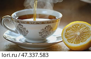 Hot tea being poured into elegant china cup with lemon. Стоковое AI-видео, аниматор Юрий Поздников / Фотобанк Лори