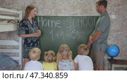 Home school concept. Parents give children a math lesson at the blackboard. Стоковое видео, видеограф Mikhail Davidovich / Фотобанк Лори
