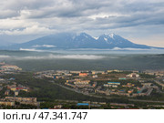 Город Петропавловск-Камчатский, Камчатский край, Дальний Восток России. Красивый городской пейзаж. Вид сверху на здания и улицы города. Вдалеке вулканы. Пасмурная погода. Низкие облака. (2022 год). Стоковое фото, фотограф Андрей Степанов / Фотобанк Лори