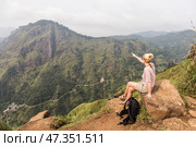 Active caucasian blonde woman enjoing fresh air and pristine nature while tracking among tea plantaitons near Ella, Sri Lanka. Bacpecking outdoors tourist adventure. Стоковое фото, фотограф Matej Kastelic / Фотобанк Лори