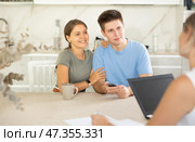 Couple of clients listen attentively and intently to woman of seller, who tells about advantages of making microloan in credit institution. Стоковое фото, фотограф Яков Филимонов / Фотобанк Лори