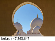 Abu Dhabi, United Arab Emirates - Jan 10 2024, View through the domed arch to the white domes of the Grand Mosque of Sheikh Zayed, at daytime, Abu Dhabi, United Arab Emirates. Редакционное фото, фотограф Сергей Богомяко / Фотобанк Лори