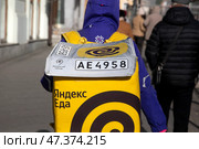 Курьер сервиса доставки "Яндекс Еда" доставляет заказ в в центре города Москвы, Россия. Редакционное фото, фотограф Николай Винокуров / Фотобанк Лори