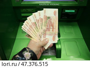 Деньги в  руке, банкноты по 5 тысяч рублей у банкомата СБЕР. Москва. 29.03.202. Стоковое фото, фотограф Ольга Зиновская / Фотобанк Лори