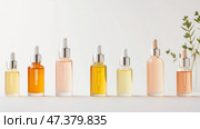 Arranged collection of colorful skincare serums on a neutral surface during daylight. Стоковое AI-изображение, AI-художник Сергей Толмачёв / Фотобанк Лори