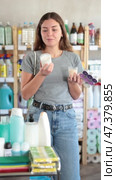 Smiling interested young woman choosing handcrafted scented candles in household goods store, selecting ideal aroma for for adding warmth and comfort to home interior. Стоковое видео, видеограф Яков Филимонов / Фотобанк Лори