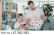 Boy with phone observe of choosing toilet paper, listen to dads explanation about quality of product. Стоковое видео, видеограф Яков Филимонов / Фотобанк Лори
