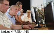 Female teacher explaining computer skills to focused senior man in nursing home computer class. Стоковое видео, видеограф Яков Филимонов / Фотобанк Лори