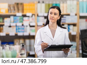 Woman pharmacist makes restock, uses electronic carrier tablet of information. Стоковое фото, фотограф Яков Филимонов / Фотобанк Лори