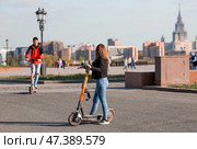People ride rented scooters on Poklonnaya Gora.Russia, Moscow, 22 April 2023. Редакционное фото, фотограф Photojuli / Фотобанк Лори