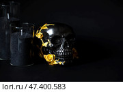 A mysterious black skull with golden roses and pumpkins for a Halloween or Day of the dead party on a black grunge background. Стоковое фото, фотограф Photojuli / Фотобанк Лори
