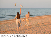 Girl throws sandals up in the ocean. Beginning of vacation, honeymoon. Стоковое фото, фотограф Irina Kuchugurina/Gaudy / Фотобанк Лори