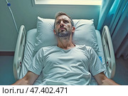 Встревоженный молодой мужчина лежит в больничной постели с задумчивым выражением. Стоковое AI-изображение, AI-художник Елена Болотина / Фотобанк Лори