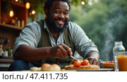 Joyful Man Enjoying a Delicious Meal Outdoors in a Cozy, Rustic Setting Surrounded by Greenery During a Sunny Afternoon. Black african man. Стоковое AI-изображение, AI-художник Sergey Grishin / Фотобанк Лори