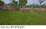 A picturesque and serene park featuring comfortable benches and a beautifully lush green lawn. Стоковое видео, видеограф Vladimir Vintonjak / Фотобанк Лори