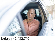 Mature man experiencing shoulder pain while driving car. Стоковое фото, фотограф Константин Шишкин / Фотобанк Лори
