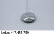 Tranquil water gracefully flows over a shiny and polished drain cover, creating calming ripples. Стоковое видео, видеограф Громов Александр / Фотобанк Лори