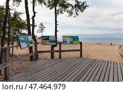 BAIKAL LAKE, KHUZHIR VILLAGE, IRKUTSK REGION, RUSSIA - August 03, 2024: Posters with describing sights of Olkhon Island on ecological trail of Saraiskiy Bay on summer day. View of sandy beach. Редакционное фото, фотограф Виктория Катьянова / Фотобанк Лори
