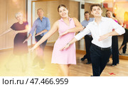 Young girl and guy enjoying upbeat swing in dance studio. Стоковое фото, фотограф Яков Филимонов / Фотобанк Лори