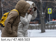 Люди идут по улице в центре города Москвы борясь с холодным, порывистым ветром, Россия. Редакционное фото, фотограф Николай Винокуров / Фотобанк Лори