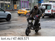 Курьер доставляет товар в центре города Москвы в холодную, ветренную погоду, Россия. Редакционное фото, фотограф Николай Винокуров / Фотобанк Лори