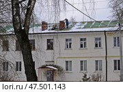 Мужчина осматривает трубу дымохода на крыше жилого дома. Редакционное фото, фотограф Лариса Вишневская / Фотобанк Лори