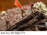 Miniature climbers scale a chocolate mountain with a flag on top in a creative dessert arrangement. Стоковое AI-изображение, AI-художник Татьяна  Бральнина / Фотобанк Лори