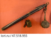 Antique metal Russian flail and weight on red background. Стоковое фото, фотограф Алексей Антипов / Фотобанк Лори