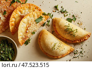 A minimalist display of empanadas showcases culinary craftsmanship on a neutral ceramic surface. Each dumpling-like pastry is filled with savory goodness, highlighting their golden, delicious appeal. Стоковое AI-изображение, AI-художник Nart / Фотобанк Лори