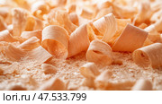 Shavings scattered across a wooden surface during woodworking process. Стружка, разбросанная по деревянной поверхности в процессе обработки дерева. Стоковое AI-изображение, AI-художник Katsiaryna Repich / Фотобанк Лори