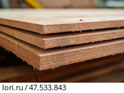 Wooden boards stacked in workshop during daylight for crafting projects. Деревянные доски, сложенные в мастерской в светлое время суток для изготовления поделок. Стоковое AI-изображение, AI-художник Katsiaryna Repich / Фотобанк Лори