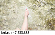 Water Rocks Feet. Feet dipped into the river water on rocks during daytime, enjoying nature's coolness. Стоковое видео, видеограф svetograph / Фотобанк Лори