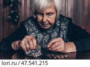 Portrait of an old woman counting money. The concept of old age, poverty, austerity. Стоковое фото, фотограф Matej Kastelic / Фотобанк Лори