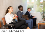 Young female visitor sitting on the bench in waiting room of clinic. Стоковое фото, фотограф Яков Филимонов / Фотобанк Лори