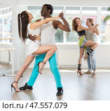 Woman dances incendiary tango with African man partner during choreography lesson. Стоковое фото, фотограф Яков Филимонов / Фотобанк Лори
