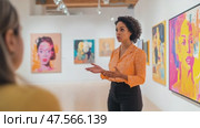 Art curator explaining modern painting to visitor in gallery. Стоковое AI-видео, аниматор Юрий Поздников / Фотобанк Лори