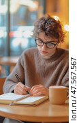 Young woman writing in notebook at cafe. Стоковое AI-видео, аниматор Юрий Поздников / Фотобанк Лори