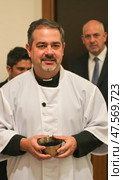 Priest Holding a Bowl of Ashes for Ash Wednesday Service in a Church Setting. Стоковое AI-изображение, AI-художник Sergey Grishin / Фотобанк Лори