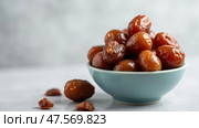 Delicious Arabian Dates Served in a Bowl for Iftar During Ramadan Festivities. Стоковое AI-изображение, AI-художник Sergey Grishin / Фотобанк Лори