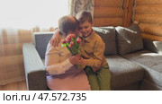 Grandma and grandson celebrate the holiday together, they dance, play balloons and give gifts and flowers. Стоковое видео, видеограф Ирина Старикова / Фотобанк Лори