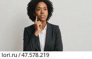 Thoughtful businesswoman pondering decisions in professional attire against neutral background. Стоковое AI-видео, аниматор Владимир Федоров / Фотобанк Лори
