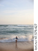 A person joyfully enjoying the waves at a beautiful sunset beach in the evening. Стоковое фото, фотограф Женя Канашкин / Фотобанк Лори