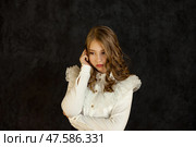 Teen Girl in a Contemplative Pose Against a Dark Background With Stylish Attire. Стоковое фото, фотограф Aleksandr Golubev / Фотобанк Лори