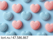 Heart-shaped bath bombs in pink and blue colors arranged on a flat surface. Разноцветные бомбочки для ванны в форме сердца розового и голубого цветов расположены в виде игривого узора на светло-голубой поверхности. Эти средства для ванны создают яркую и привлекательную атмосферу. Стоковое AI-изображение, AI-художник Katsiaryna Repich / Фотобанк Лори