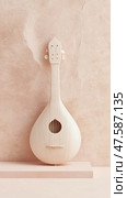 Pale Wood Lute Against Peach Wall. Стоковое AI-изображение, AI-художник Данила Большаков / Фотобанк Лори