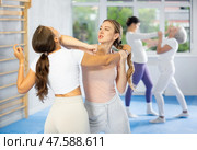 Woman and girl in gym perform basic elements of krav maga self-defense system. Стоковое фото, фотограф Яков Филимонов / Фотобанк Лори