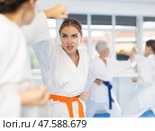 Young female karateka working on hand strikes in sparring at training. Стоковое фото, фотограф Яков Филимонов / Фотобанк Лори