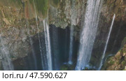 Powerful waterfall cascading over rocky cliff edge, plunging into turquoise water pool, surrounded by verdant moss and greenery in scenic turkish landscape. Стоковое видео, видеограф ILIA GOROKHOV / Фотобанк Лори