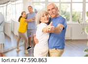 Senior woman and man dancing slow ballroom dance during group class. Стоковое фото, фотограф Яков Филимонов / Фотобанк Лори