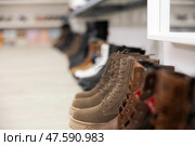 On wooden white shelve of store there are various items of women shoes boots. Стоковое фото, фотограф Яков Филимонов / Фотобанк Лори